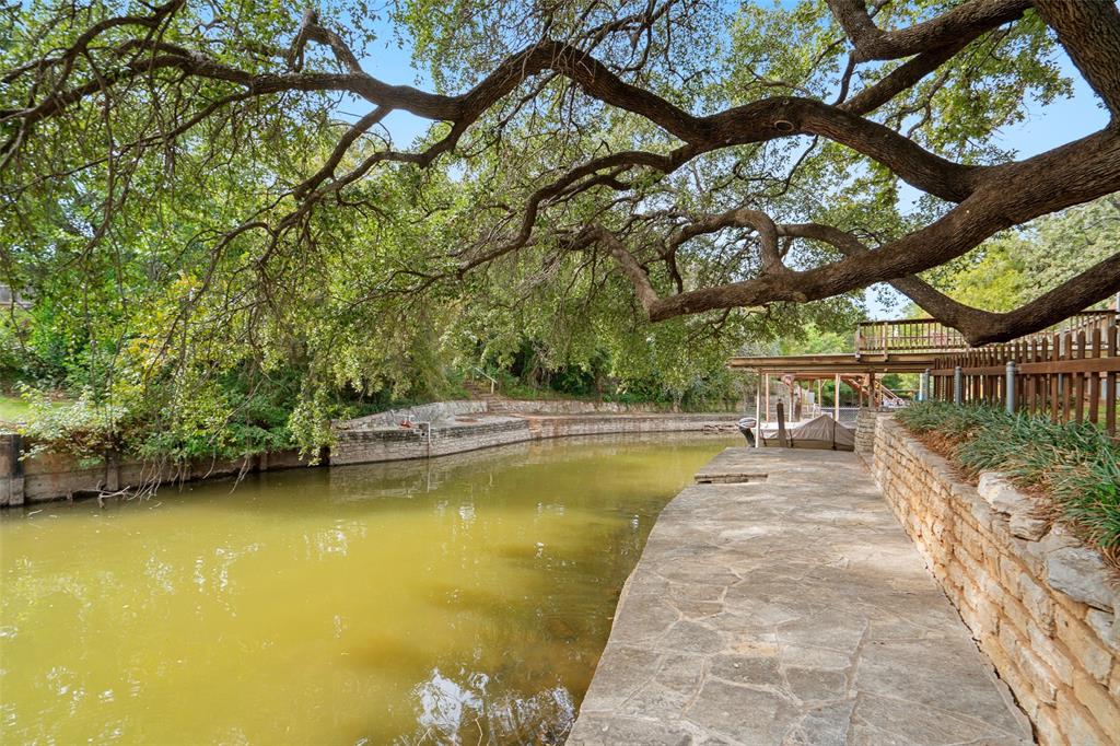View of canal with stone wall and mature oak tree