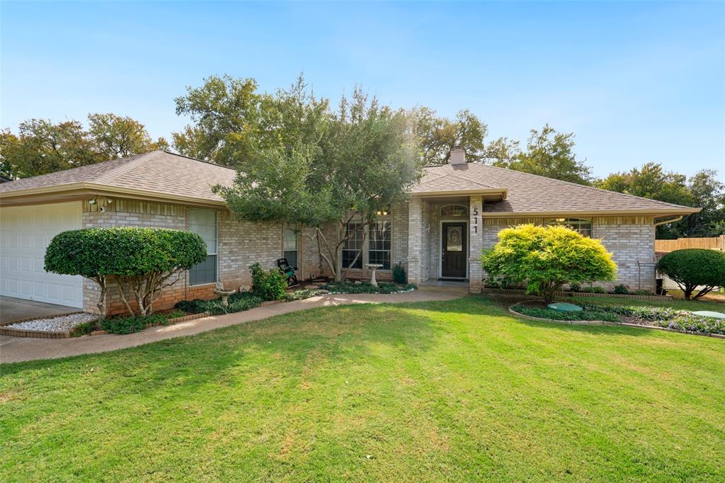 Single-story masonry exterior featuring a hip roof, two-car garage, recessed entryway, and manicured landscaping Single-story masonry exterior featuring a hip roof, two-car garage, recessed entryway, and manicured landscaping