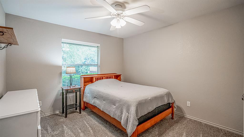 Neutral-toned interior featuring carpeting, a ceiling fan, and a window treatments