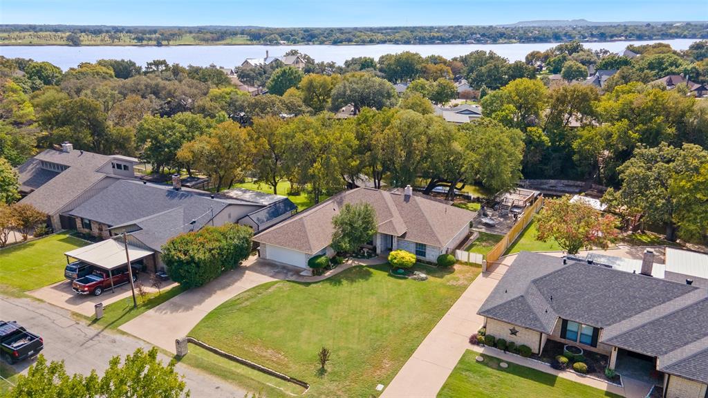 Aerial perspective featuring expansive lawns, mature trees, and waterfront scenery