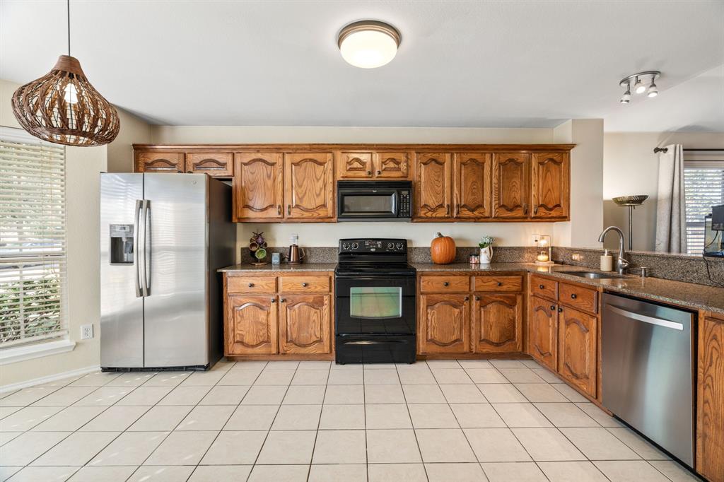 The kitchen boasts a pantry, SS refrigerator, SS dishwasher, an electric range and a microwave.