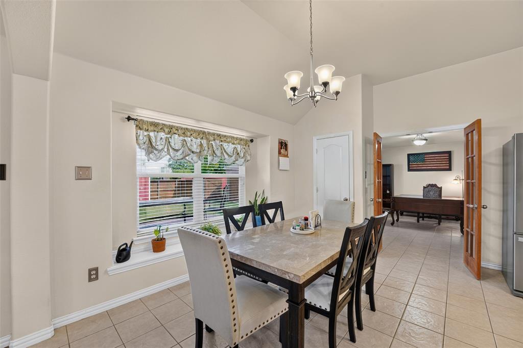 Spacious dining room with vaulted ceiling, large picture window with a charming window seat, and abundant natural light.