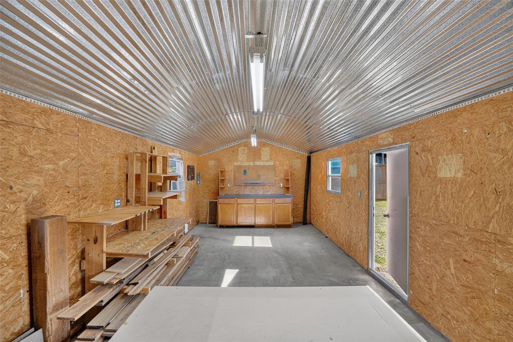 Inside of the workshop with cabinetry, lighting and a wall AC unit.