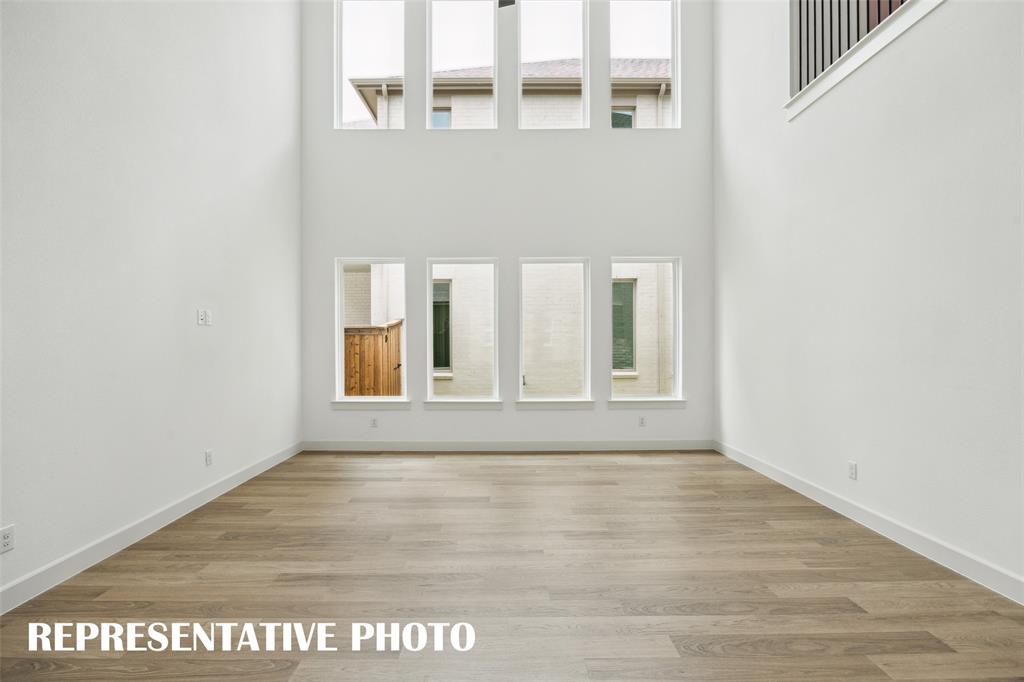Your new family room is flooded with natural light from a double stacked wall of windows!  REPRESENTATIVE PHOTO