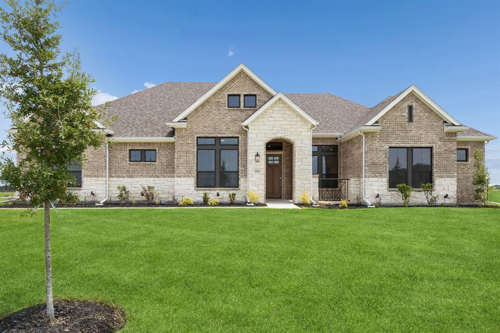 Brick and stone exterior facade featuring a covered entryway, multi-gabled roofline, and dark-framed windows