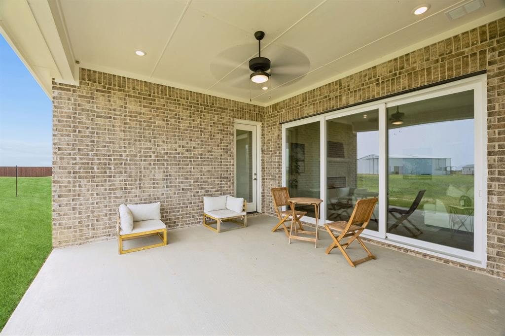 Covered patio featuring a brick exterior, concrete flooring, recessed lighting, and a ceiling fan, including large sliding glass doors