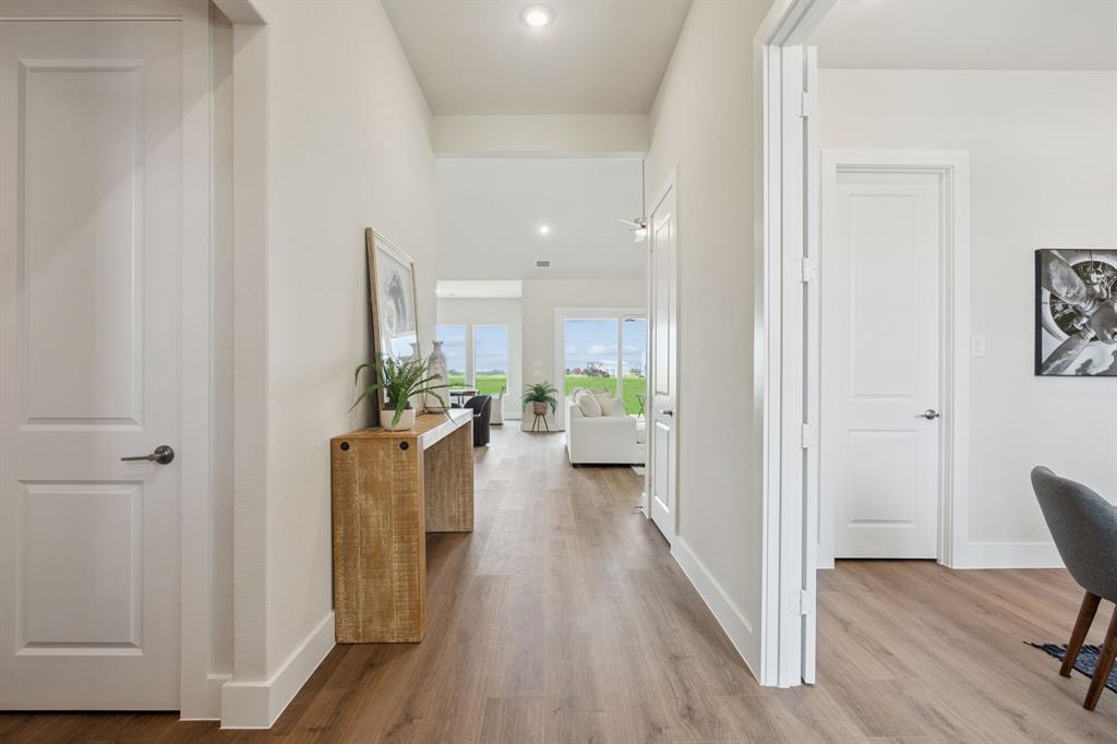 Interior hallway featuring wood-finish flooring, white panel doors, and recessed lighting