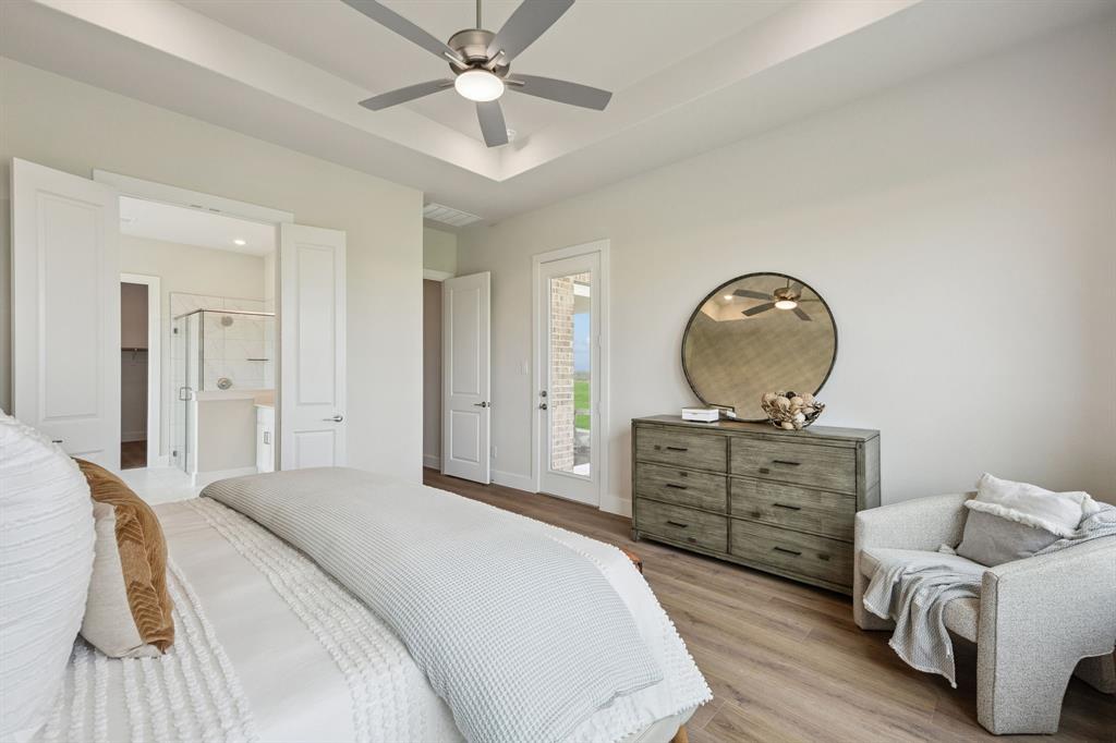 Tray ceiling with recessed lighting, brushed nickel ceiling fan, wood-finish flooring, and a glass-paneled exterior door