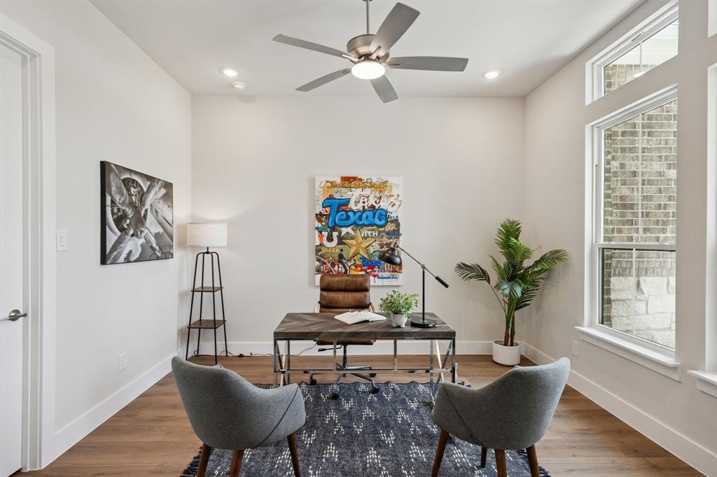 Room featuring wood-finish flooring, recessed lighting, a brushed-metal ceiling fan, and tall windows with natural light
