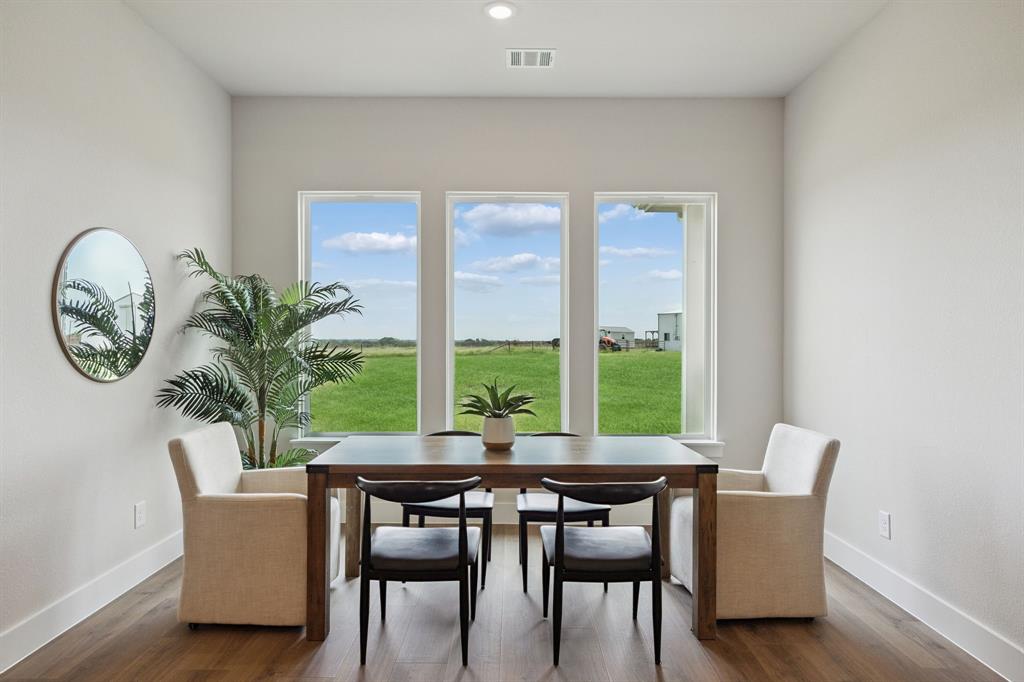 Triple window configuration with neutral-toned interior walls, wood-finish flooring, and recessed ceiling lighting