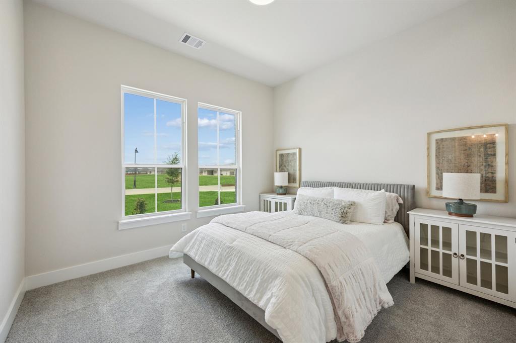 Neutral-toned interior space featuring high ceilings, wall-to-wall carpeting, and large dual-pane windows with grids