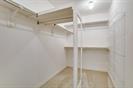 Walk-in closet featuring multi-level white wire shelving and light-toned wood-finish flooring