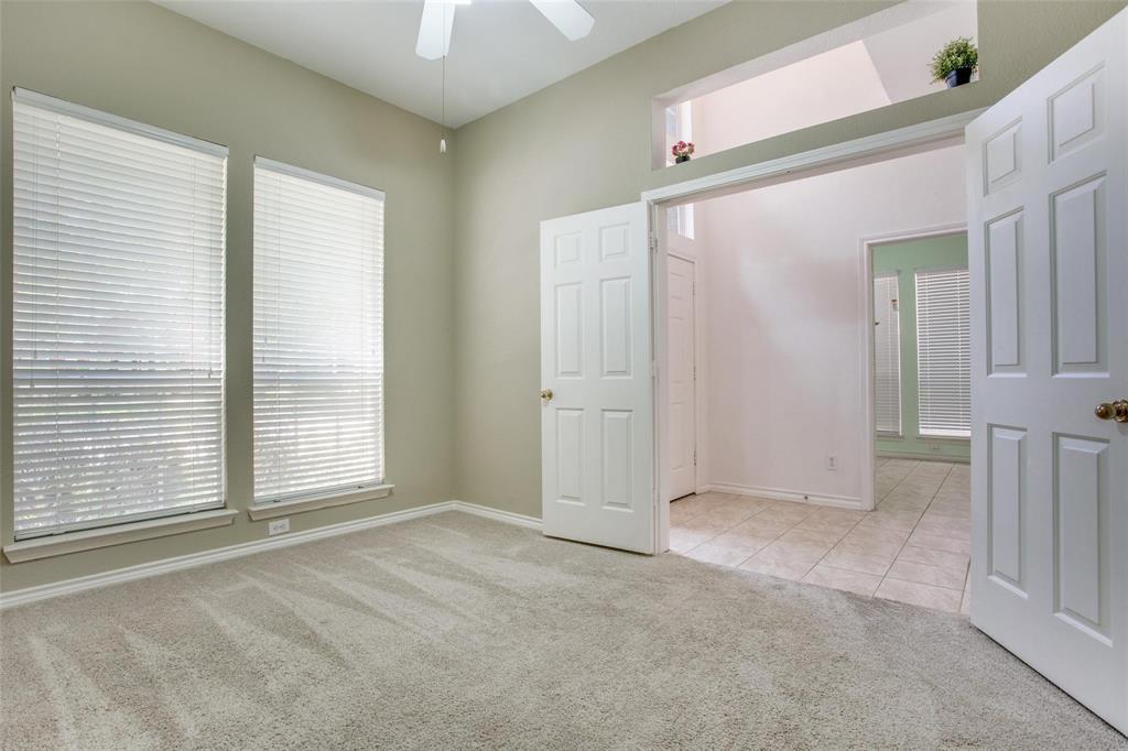 Room featuring neutral-toned carpeting, dual windows with blinds, a ceiling fan, and a recessed architectural niche