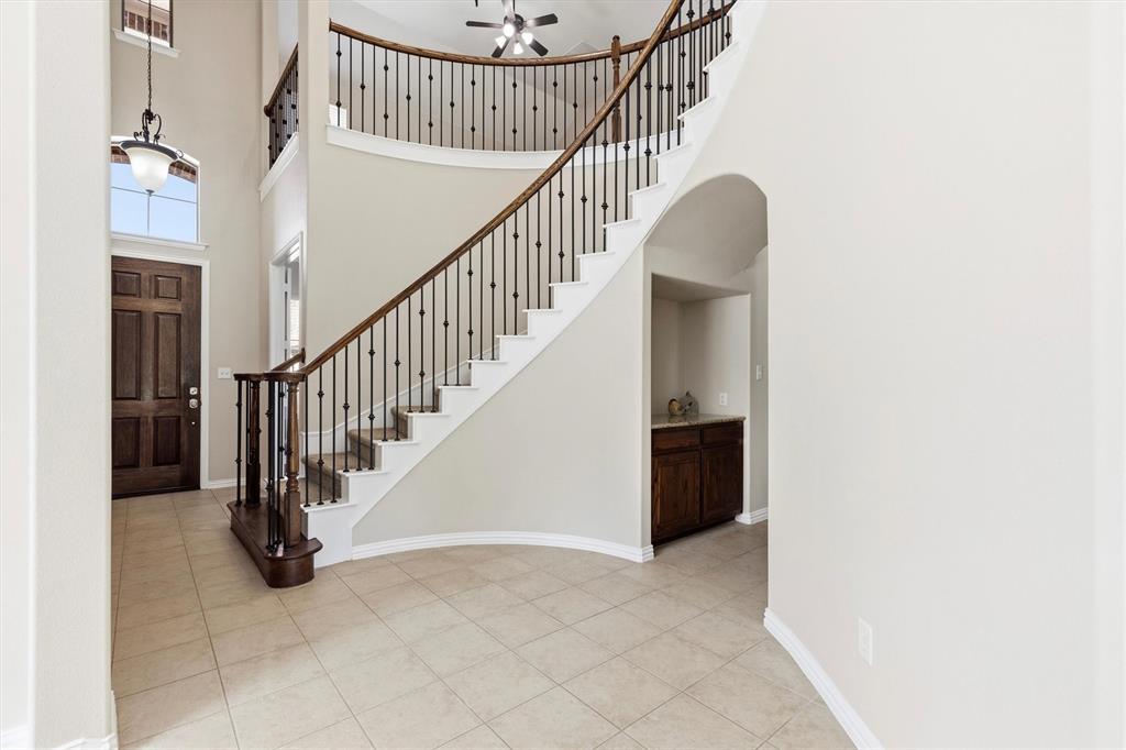 View of grand staircase and planning nook off the kitchen