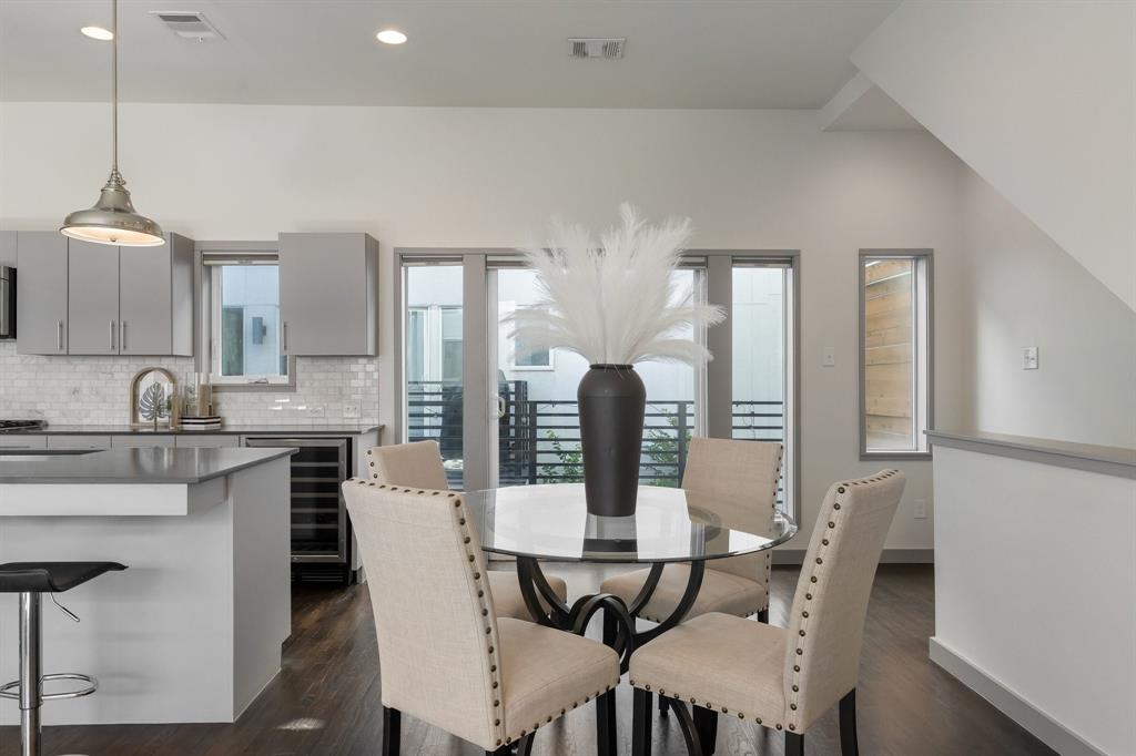Kitchen featuring gray flat-panel cabinetry, light-toned tiled backsplash, integrated wine refrigerator, and wood-finish flooring