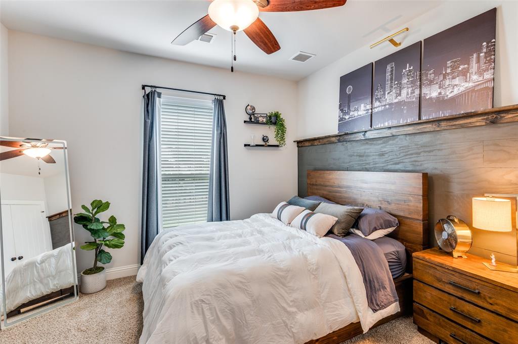Horizontal wood-plank accent wall with built-in wood shelving, ceiling fan with light fixture, window with horizontal blinds, and carpeted flooring