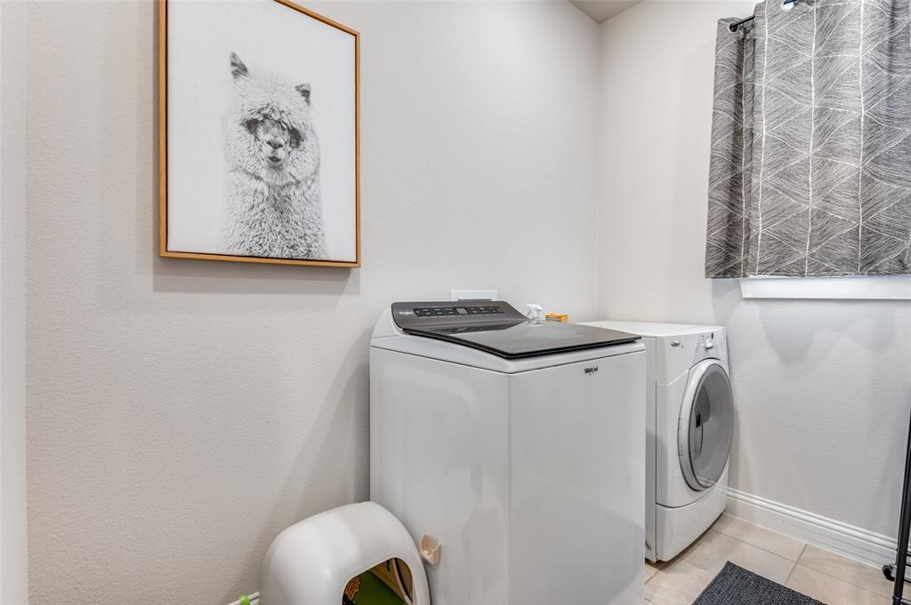Laundry area featuring neutral wall paint and tile flooring