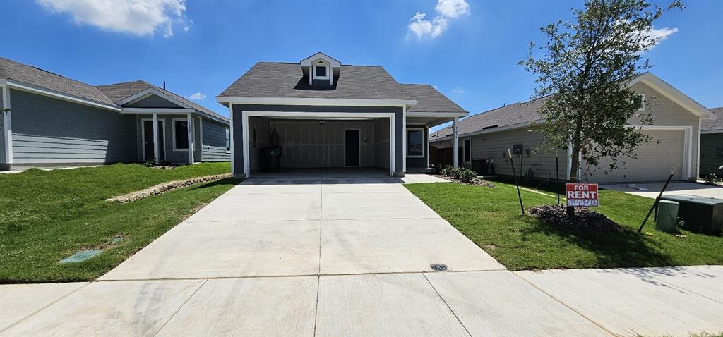 View of front of property featuring concrete driveway, a shingled roof, and a front lawn