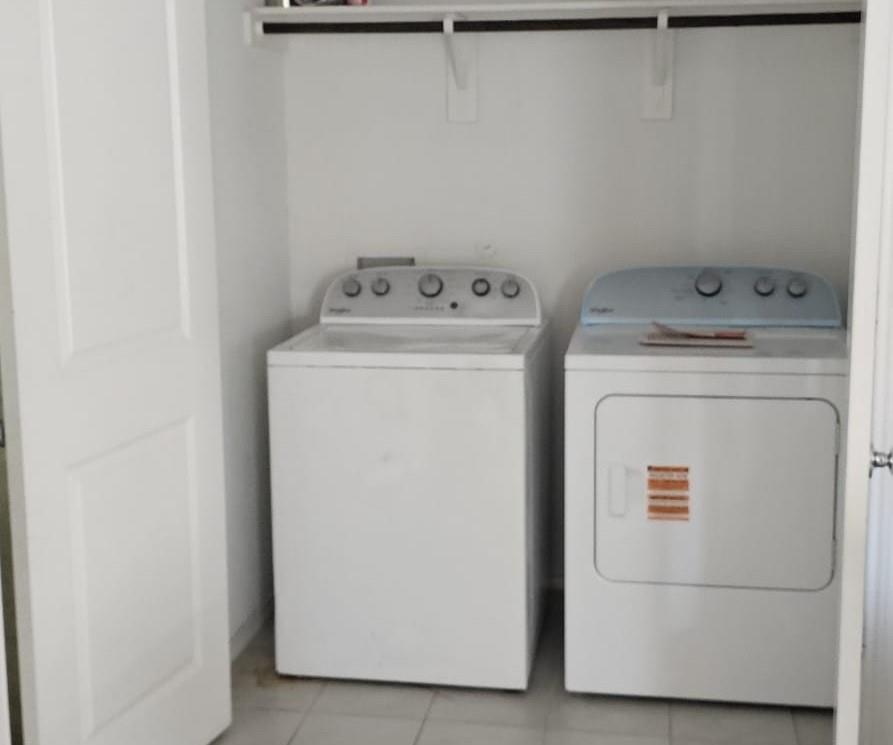 Laundry area with light tile patterned floors and separate washer and dryer