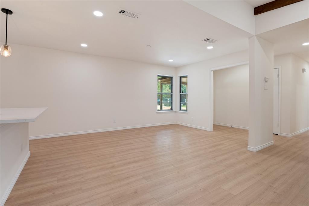Open interior featuring wood-finish flooring, recessed lighting, a built-in counter, and multi-pane windows