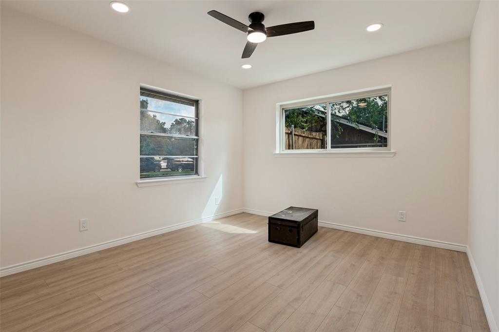 Room featuring wood-finish flooring, recessed lighting, a modern ceiling fan, and dual windows