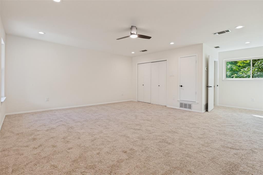 Spacious interior featuring neutral carpeting, recessed lighting, a modern ceiling fan, and double-door closet storage