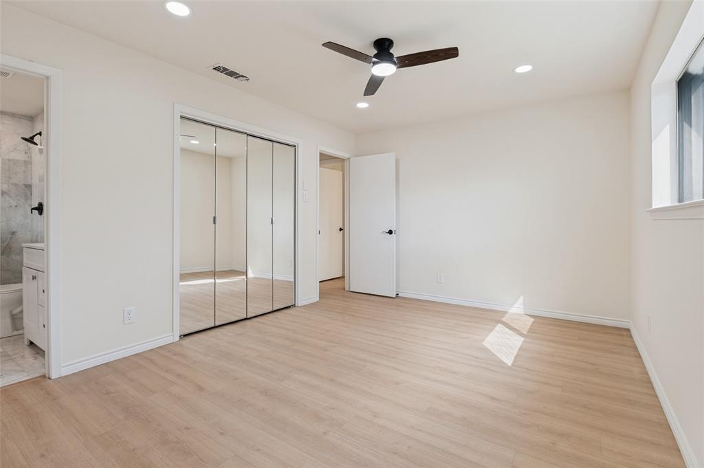 Neutral interior space featuring wood-finish flooring, recessed lighting, a modern ceiling fan, and floor-to-ceiling mirrored closet doors
