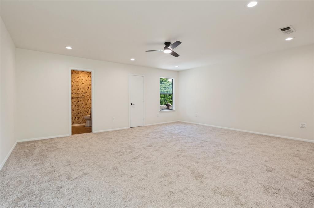 Neutral-toned carpeting, recessed lighting, ceiling fan with integrated light, and natural light via single-pane window