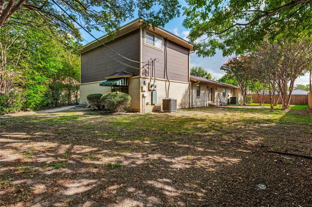 Exterior featuring a two-story elevation, horizontal siding, masonry base, and a fenced backyard with mature trees