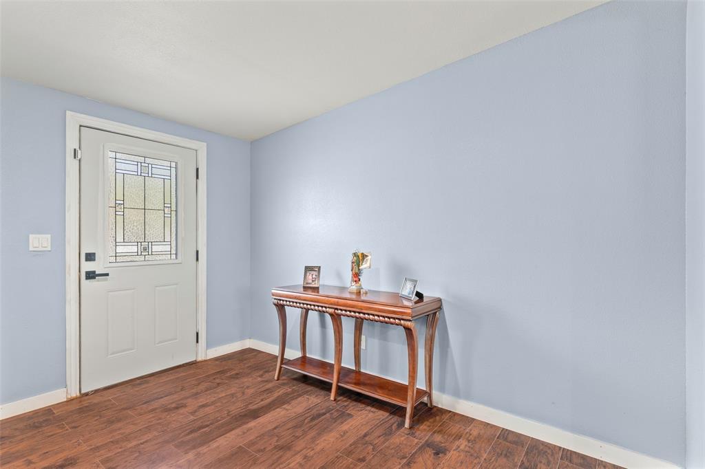 Entryway featuring wood-finish flooring and a single-panel exterior door with a decorative glass insert and matte black hardware