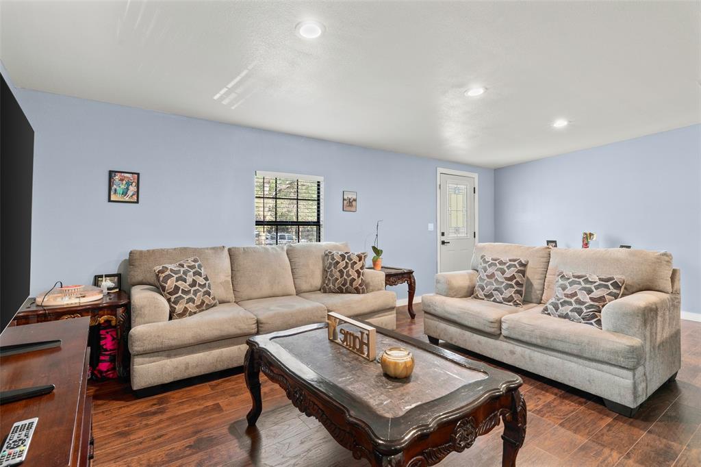 Living area featuring wood-finish flooring, recessed lighting, and a single-light exterior door with a decorative glass insert