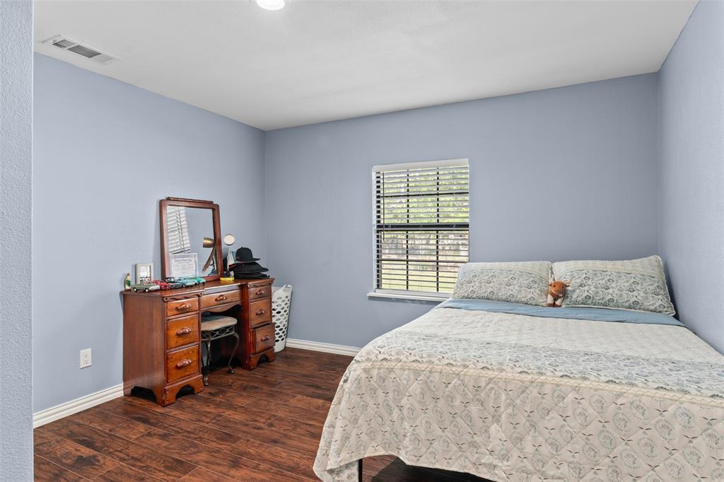 Interior space featuring wood-finish flooring and a single-hung window with horizontal blinds