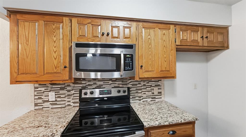 Stove and microwave view with granite