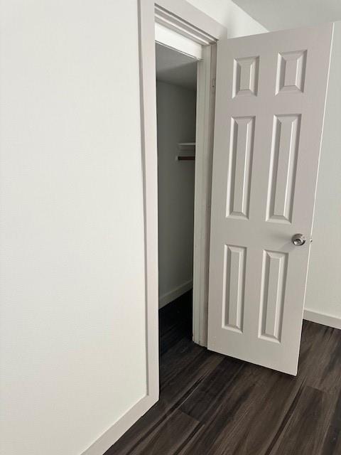 Six-panel interior door featuring a metallic knob and wood-finish flooring
