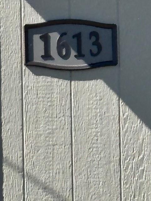 Custom address plaque featuring raised black numerals mounted on vertical wood-texture paneling