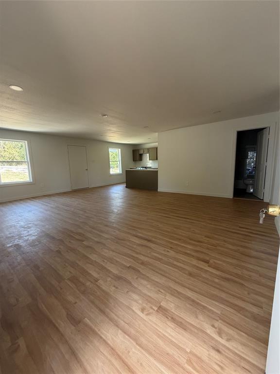 Open-concept interior featuring wood-finish flooring, recessed lighting, and multiple windows