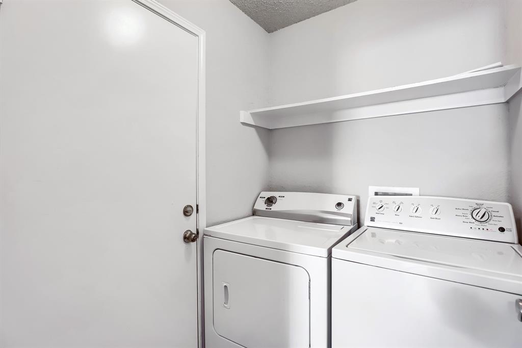 Utility area featuring a wall-mounted shelving unit and a door with metallic hardware