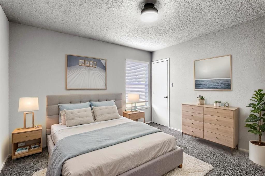 Virtually Staged -Neutral-toned room featuring wall-to-wall carpeting, textured ceiling, flush-mount lighting, and window blinds