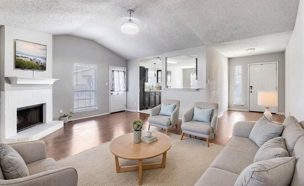 Virtually Staged -Vaulted ceilings, painted brick fireplace with mantel, and wood-finish flooring