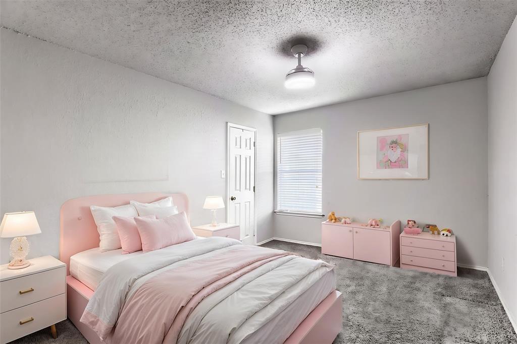 Room featuring neutral wall finishes, grey carpeting, a multi-panel interior door, and a ceiling-mounted light fixture