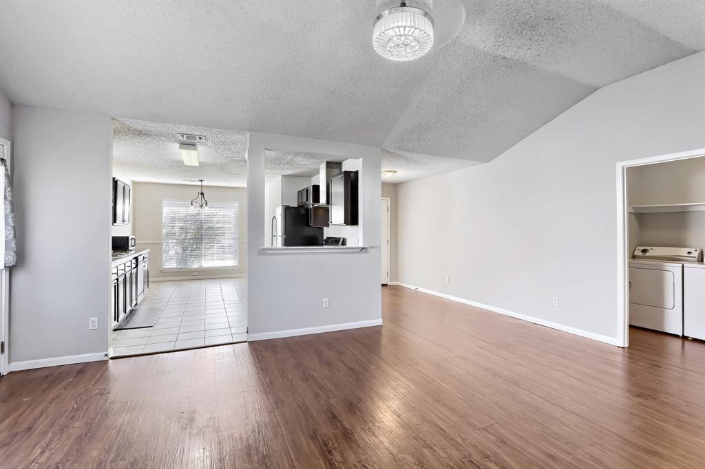 Vaulted ceilings, wood-finish flooring, kitchen pass-through window, and dedicated laundry area