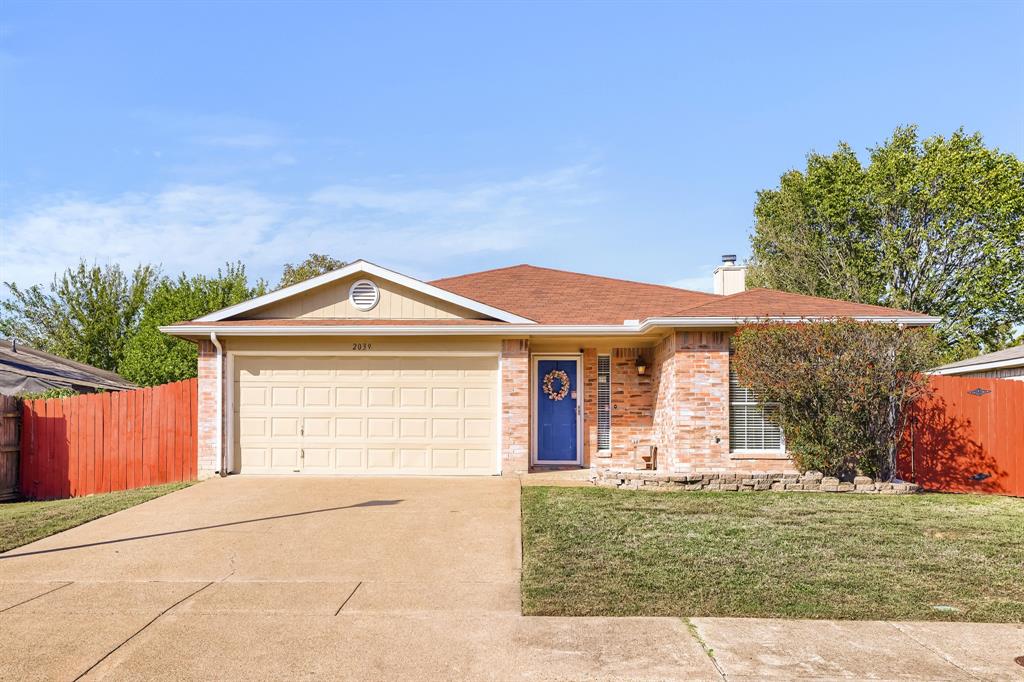 Single-story residence featuring a brick and siding exterior, attached two-car garage, concrete driveway, and a front landscape with a stone border Single-story residence featuring a brick and siding exterior, attached two-car garage, concrete driveway, and a front landscape with a stone border
