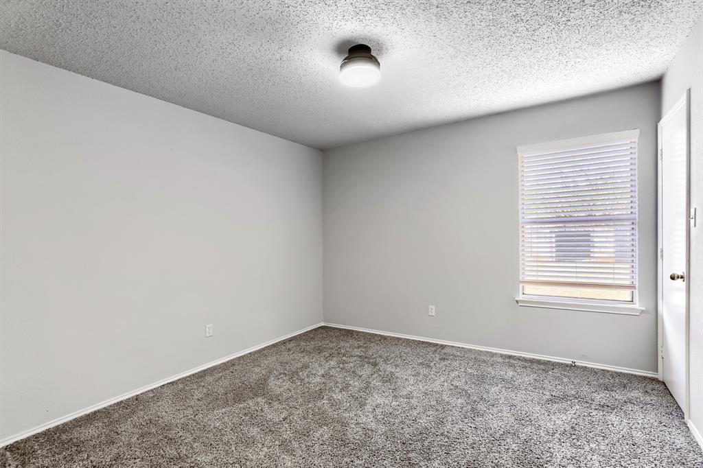 Neutral-toned walls, wall-to-wall carpeting, window with adjustable blinds, and central flush-mount lighting