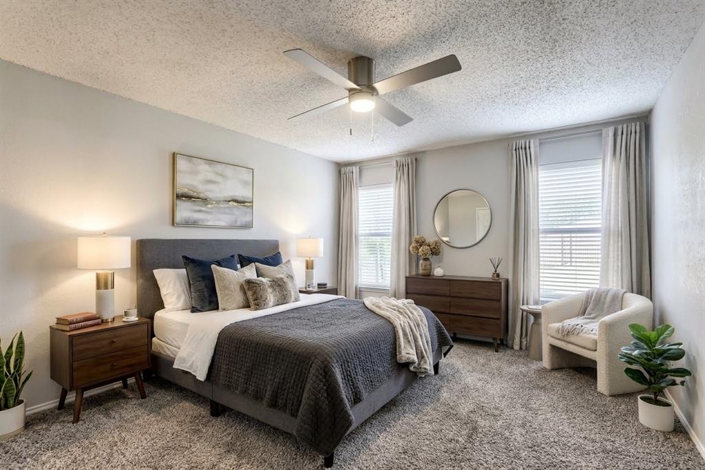 Virtually Staged -Bedroom featuring wall-to-wall carpeting, dual windows, and a ceiling-mounted light fixture with a fan