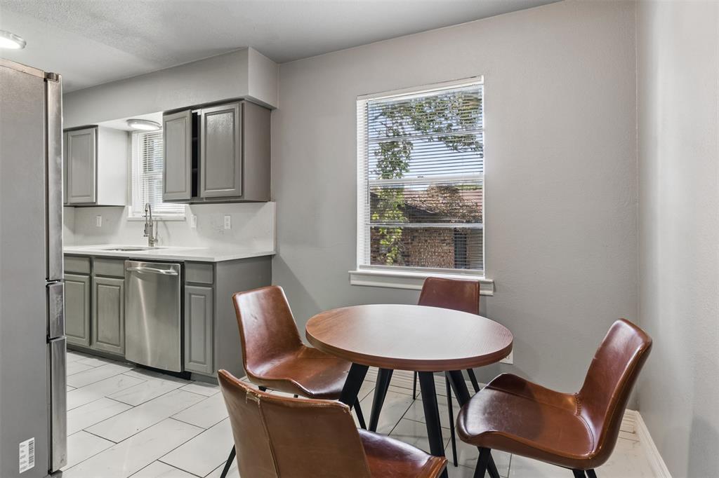 Kitchen featuring gray cabinetry, stainless steel dishwasher, white countertops, tile flooring, and a single-pane window