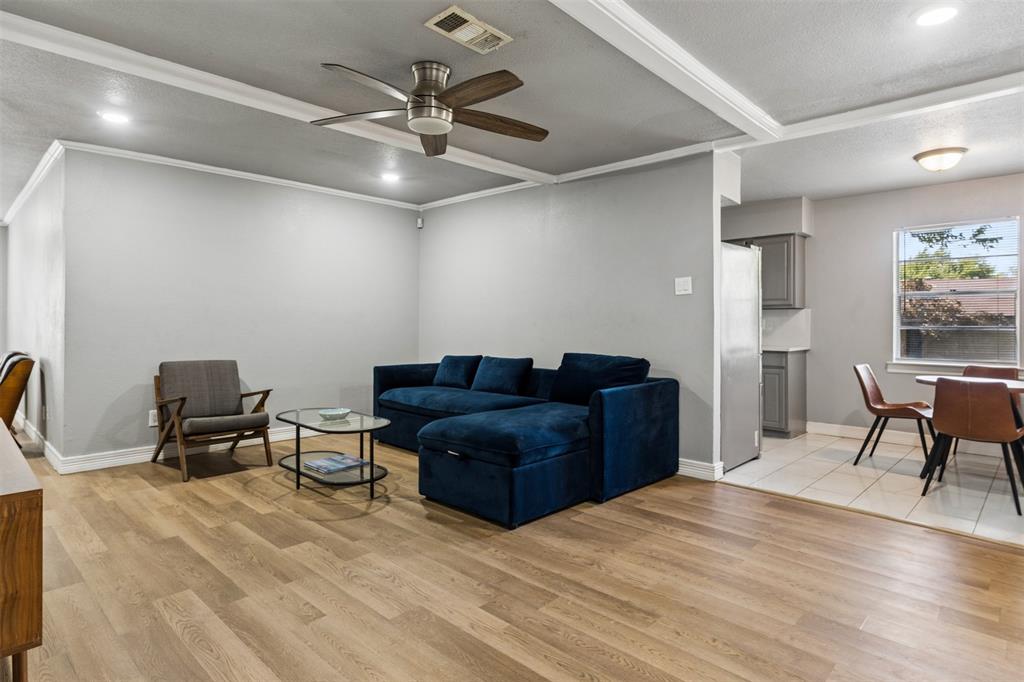 Living area featuring a tray ceiling, recessed lighting, and a multi-blade ceiling fan, complemented by wood-finish flooring throughout