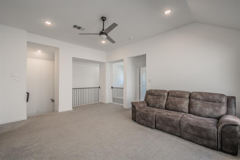 Vaulted ceilings, recessed lighting, matte black ceiling fan, and metal balustrade railings