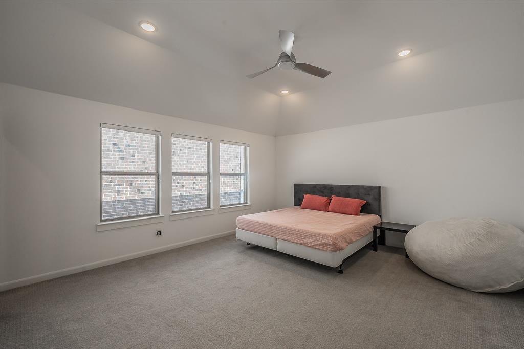 Vaulted ceilings featuring recessed lighting and a brushed-metal ceiling fan, three double-pane windows, and neutral carpeting in the primary bedroom