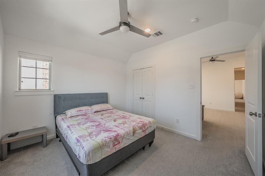 First of 2 secondary bedrooms features a ceiling fan, carpeted flooring and 2 windows for natural light