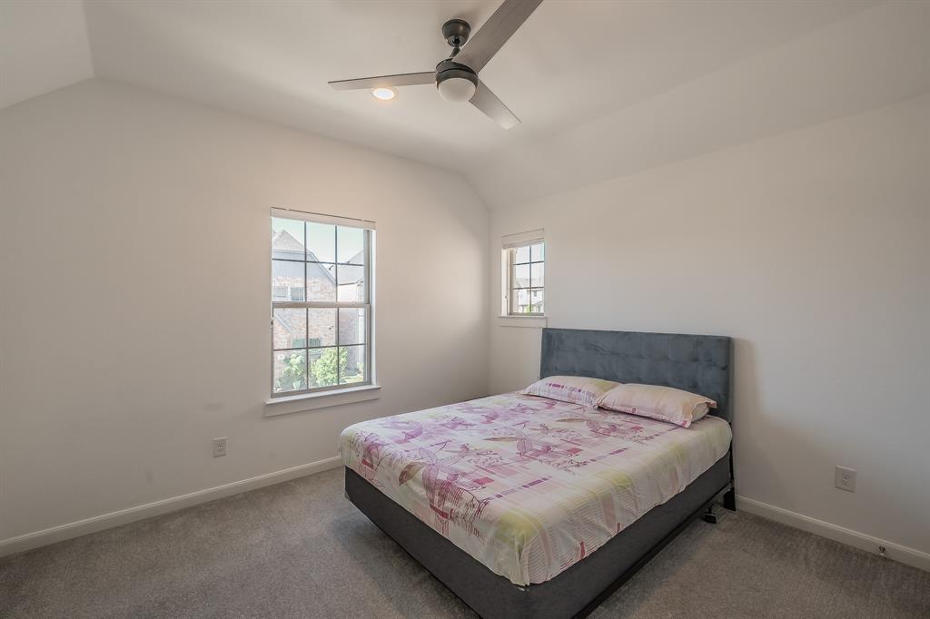 First of 2 secondary bedrooms features a ceiling fan, carpeted flooring and 2 windows for natural light